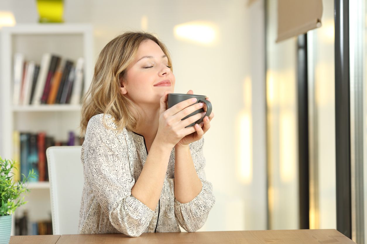 La femme apprécie l'arôme du café le matin.