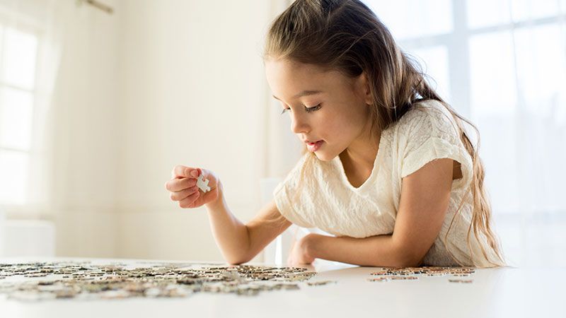 Petite fille faisant un puzzle. 